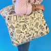 Vidéo du sac cabas Pop OMY à colorier, porté à l'épaule, illustré de motifs pop noir et blanc, sur fond bleu