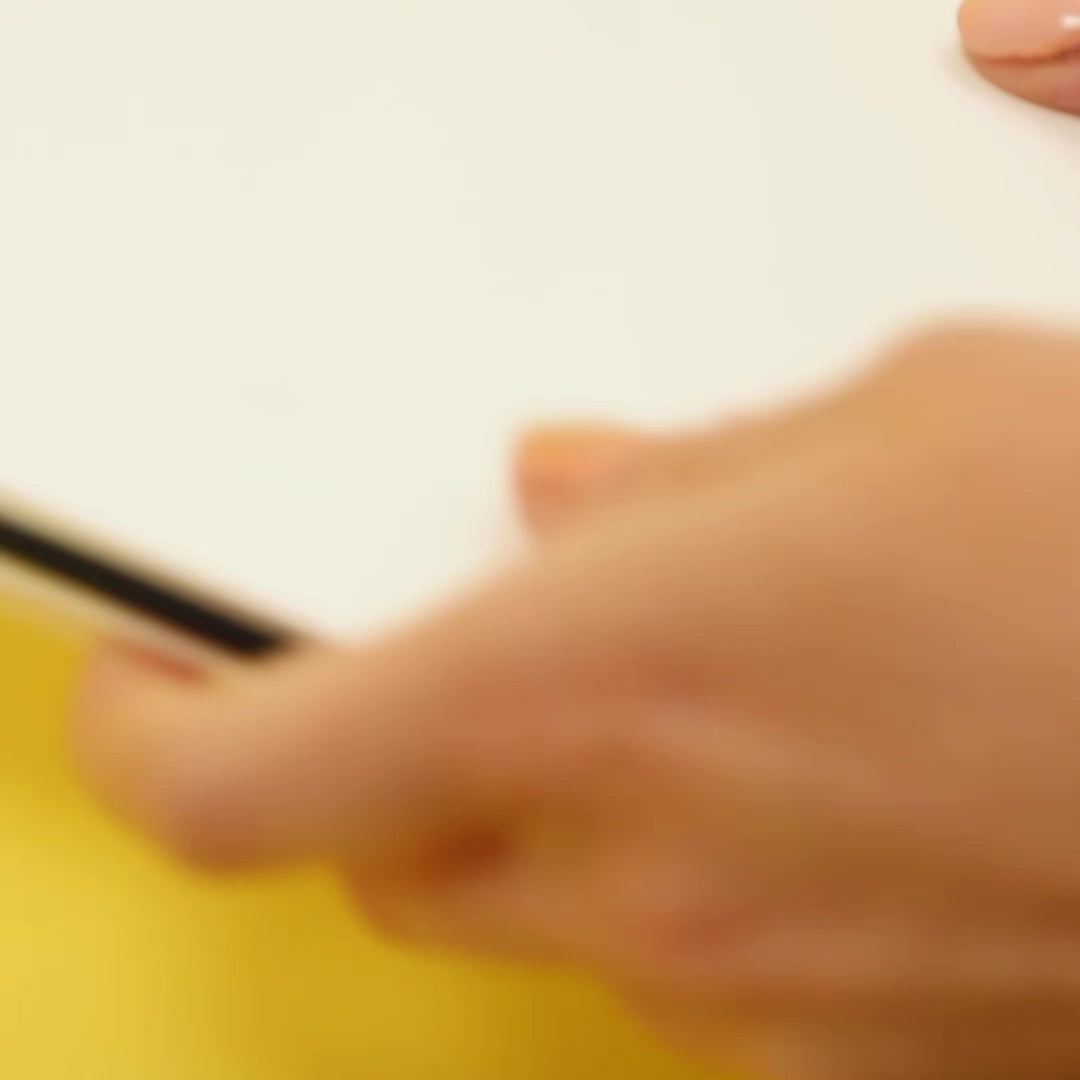 Vidéo de démonstration des feutres parfumés OMY : une main dessine avec un feutre violet sur une feuille blanche