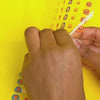 Vidéo d'une enfant posant sur ses ongles les Nail Stickers Kawaii OMY : oursons, lapins et hérissons, sur fond jaune